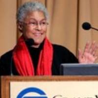 Patricia Hill Collins presenting behind a podium with the Grand valley state logo present